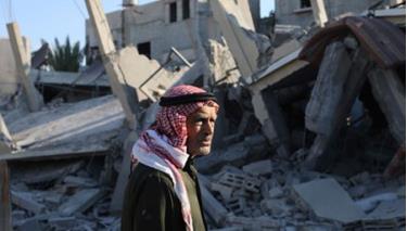 Người đàn ông Palestine trước đống đổ nát ở dải Gaza.