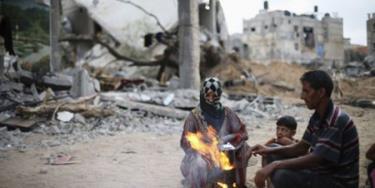 Người dân Palestine bên những đống đổ nát ở dải Gaza.