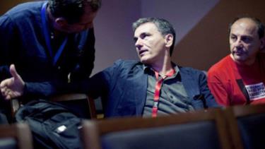 Bộ trưởng Tài chính Hy Lạp Euclid Tsakalotos (giữa) nói chuyện một một thành viên trong đảng Syriza trong một cuộc họp vào tháng 7 vừa qua tại Athens.