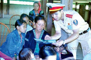 Cán bộ Đội Cảnh sát Giao thông trật tự cơ động Công an huyện Văn Chấn  phát tờ rơi, tuyên truyền pháp luật về an toàn giao thông đến người dân.