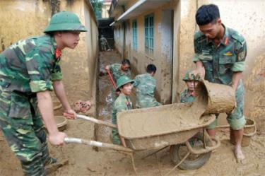 Lực lượng vũ trang tham gia làm sạch vệ sinh môi trường tại khu vực Trung tâm bồi dưỡng chính trị huyện.