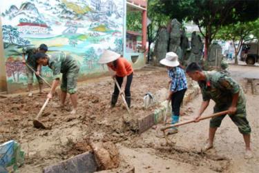 Cán bộ, chiến sỹ lực lượng vũ trang cùng các cô giáo tiến hành dọn dẹp vệ sinh môi trường tại Trường Mầm non Hoa Lan.
