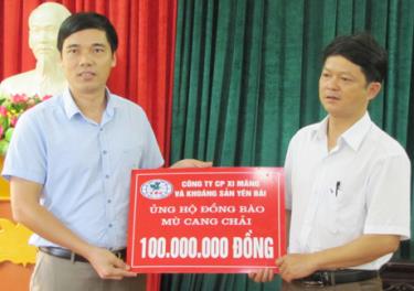 Ông Nguyễn Hồng Phong - Phó Giám đốc Công ty cổ phần Xi măng và Khoáng sản Yên Bái trao tượng trưng 100 triệu đồng cho đại diện huyện Mù Cang Chải.