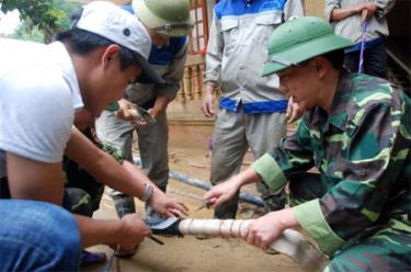 Phó Chủ tịch Thường trực UBND huyện Mù Cang Chải Lê Trọng Khang (phải) trực tiếp hướng dẫn các lực lượng khắc phục hậu quả bão lũ tại hiện trường tổ 8, thị trấn Mù Cang Chải.