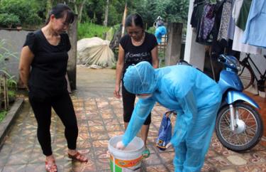 Cán bộ Trung tâm Y tế thành phố Yên Bái hướng dẫn người dân pha thuốc thanh khiết môi trường, không để muỗi phát triển.