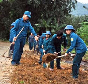 Anh Hoàng Văn Huyền (bên trái) cùng lực lượng dân quân xã Khánh Thiện tham gia lao động tại địa phương.