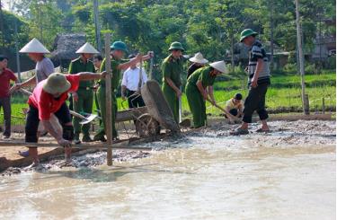 Cán bộ, chiến sĩ Công an huyện Yên Bình giúp người dân làm đường giao thông nông thôn.