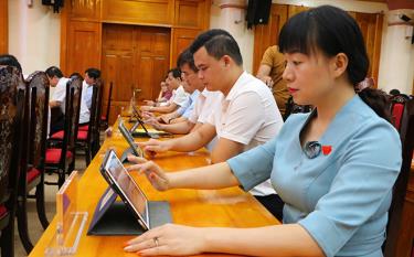 Các đại biểu HĐND tỉnh biểu quyết trên máy tính bảng.