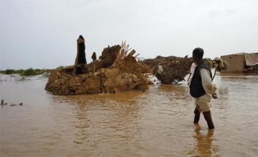 Một người dân lội qua khu vực bị ngập lụt ở Kassala, Sudan, ngày 18/8/2022.