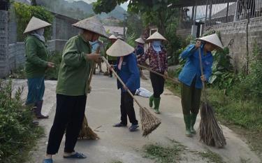 Hội viên phụ nữ xã Hưng Khánh tham gia vệ sinh môi trường giao thông nông thôn.