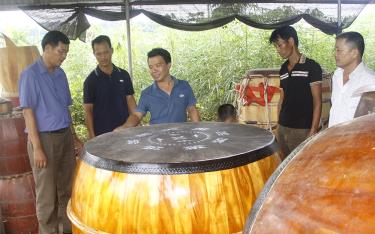 Anh Mạnh (giữa) giới thiệu với lãnh đạo Phòng Văn hóa và Thông tin huyện Yên Bình chiếc trống đại mới hoàn thành.