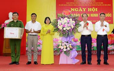 Đồng chí Tạ Văn Long - Phó Bí thư Thường trực Tỉnh ủy, Chủ tịch HĐND tỉnh và đồng chí Vũ Quỳnh Khánh - Phó Chủ tịch HĐND tỉnh tặng hoa chúc mừng Ngày hội Toàn dân bảo vệ ANTQ tại xã Tân Lĩnh.