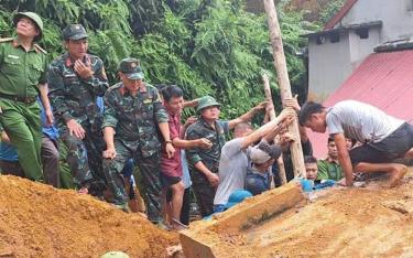 Lực lượng cứu hộ và người dân khẩn trương cứu hộ anh Lương Văn Ba bị mắc kẹt do sạt lở đất.