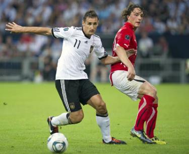 Tiền đạo Miroslav Klose (trái, tuyển Đức) đi bóng trước tiền vệ Julian Baumgartlinger của đội tuyển Áo.
