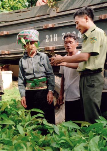 Cán bộ Hạt Kiểm lâm Văn Chấn hướng dẫn người dân kỹ thuật trồng rừng.