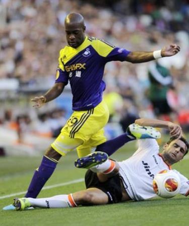 Helder Postiga (Valencia) nỗ lực truy cản pha đi bóng của Dwight Tiendalli (Swansea).
