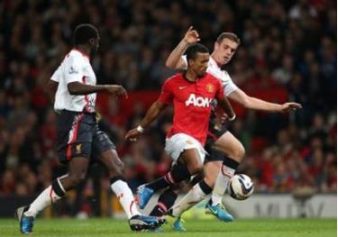 Tiền vệ Luis Nani (áo đỏ, Man.United) đi bóng giữa Kolo Toure (trái) và Henderson của Liverpool.
