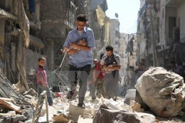 Sơ tán các em nhỏ Syria ra khỏi một tòa nhà bị sập sau vụ không kích nhằm ở thành phố Aleppo.