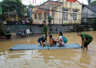 Lực lượng chức năng giúp học sinh tới trường bằng mảng.