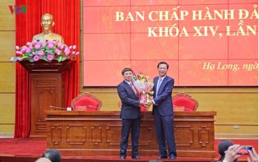 Ông Nguyễn Xuân Ký (bên trái), tân Bí thư Tỉnh ủy Quảng Ninh nhận hoa chúc mừng từ người tiền nhiệm, ông Nguyễn Văn Đọc.