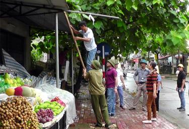 Các lực lượng chức năng thị trấn Cổ Phúc tháo dỡ hàng quán lấn chiếm vỉa hè.