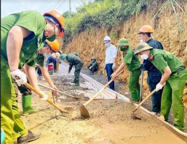 Cán bộ, chiến sĩ Công an huyện Văn Chấn tham gia cùng dân làm đường giao thông tại các thôn bản vùng cao.