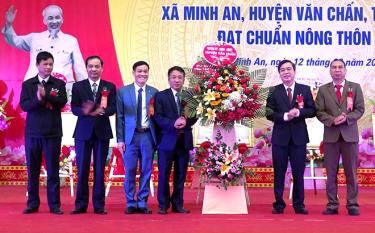 Lãnh đạo huyện Văn Chấn tặng hoa chúc mừng xã Minh An đạt chuẩn nông thôn mới.