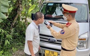 Cán bộ Đội Cảnh sát giao thông - Trật tự, Công an huyện Văn Chấn kiểm tra nồng độ cồn người điều khiển phương tiện đưa đón học sinh trên địa bàn.