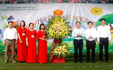 Thừa ủy quyền, đồng chí Chánh văn phòng Tỉnh ủy Trần Ngọc Luận tặng lẵng hoa của đồng chí Đỗ Đức Duy - Ủy viên BCH Trung ương Đảng, Bí thư Tỉnh ủy cho cô trò Trường Mầm non Tân Nguyên