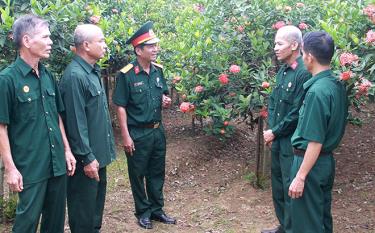 Lãnh đạo Hội Cựu chiến binh huyện Trấn Yên trao đổi phương pháp phát triển mô hình kinh tế hộ gia đình với các hội viên xã Y Can.