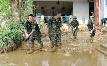 Các cán bộ chiến sĩ tích cực giúp nhân dân thu dọn bùn đất và rác sau mưa lũ tại phường Hồng Hà