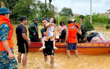 Cán bộ, chiến sĩ Trung đoàn Không quân 921 dầm mình trong mưa, đưa người dân về nơi tạm trú an toàn.