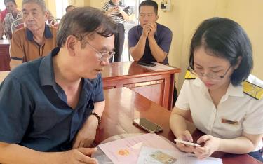 Cán bộ Chi cục Thuế thành phố m88 trang cá cược the thao hướng dẫn người dân xã Minh Bảo cài đặt ứng dụng ứng dụng Etax Mobile.