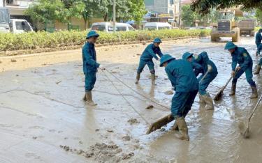 Lực lượng dân quân tự vệ thị xã Nghĩa Lộ tham gia hót, dọn bùn đất tại đường Nguyễn Thái học, thành phố Yên Bái.