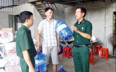 Cựu chiến binh Vũ link dafabet Thuấn (bên phải) giới thiệu quy trình sản xuất nước tinh khiết.