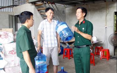 Cựu chiến binh Vũ Minh Thuấn (bên phải) giới thiệu quy trình sản xuất nước tinh khiết.