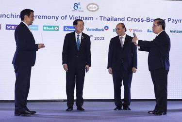 Chủ tịch nước Nguyễn Xuân Phúc và Bộ trưởng Bộ Tài chính Thái Lan chứng kiến lễ công bố kết nối thanh toán bán lẻ ứng dụng mã phản hồi nhanh (QR code) giữa Việt Nam-Thái Lan. (Ảnh: Vietnam+)