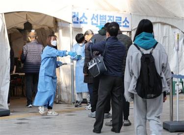 Nhân viên y tế hướng dẫn người dân tại một điểm xét nghiệm COVID-19 ở Seoul, Hàn Quốc, ngày 21/11.
