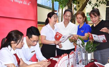 Cán bộ Ngân hàng Agribank Lục Yên hướng dẫn người dân thị trấn Yên Thế cài đặt ứng dụng thanh toán điện tử trên điện thoại thông minh.