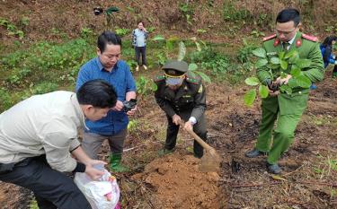 Cán bộ Công an xã Phúc Lợi giúp dân trồng rừng kinh tế.