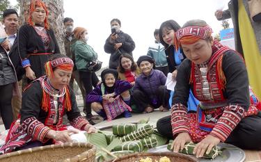 Locals and tourists experience Chung cake wrapping in market space.
