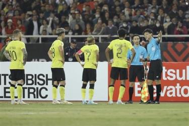 Các cầu thủ Malaysia phản ứng sau tình huống trọng tài cho đội tuyển Việt Nam hưởng quả phạt 11m ở phút 64, trong trận đấu vòng bảng AFF Cup 2022 trên sân vận động Mỹ Đình tối 27/12.