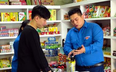 Đoàn viên thanh niên Huyện đoàn Yên Bình hướng dẫn các hộ kinh doanh cài đặt ứng dụng trên điện thoại thông minh.