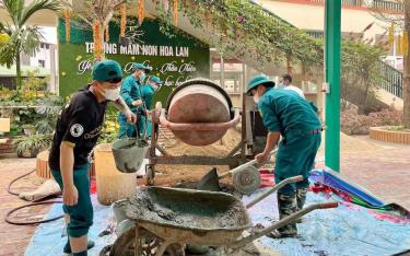 Cán bộ, chiến sĩ Ban Chỉ huy quân sự thị xã Nghĩa Lộ và phường Pú Trạng chung tay giúp đỡ Trường Mầm non Hoa Lan xây dựng vườn ươm cho bé.