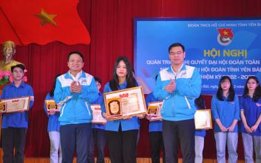 Leaders of Yen Bai province’s Ho Chi Minh Communist Youth Union present the “student with three good criteria” title to excellent students in the 2021-2022 academic year. (Illustrative photo).