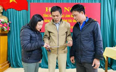 Bí thư Chi bộ Trần Đức Thanh (đứng giữa) và đảng viên trong Chi bộ trao đổi các nội dung xây dựng nông thôn mới, đô thị văn minh.