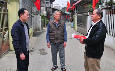 Ông Nguyễn Xuân Ngọ - Bí thư Chi bộ tổ dân phố số 8, phường Yên Thịnh (bên phải) trao đổi với các đảng viên về công tác tự quản vệ sinh môi trường.