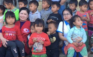 Chị Hoàng Thị Nam (mặc áo đỏ) cùng các em nhỏ vùng cao trong một chuyến thiện nguyện.
