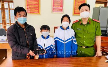 Hai em Lù Thị Mai và Lù A Đức cùng Công an xã Púng Luông, huyện Mù Cang Chải trao trả tài sản cho người bị đánh rơi.