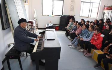Thầy Yan đàn cho học sinh hát trong một tiết âm nhạc tại trường Tiểu học Zhuwan thuộc huyện Định Viễn, thành phố Trừ Châu, tỉnh An Huy, hôm 23/3/2021.